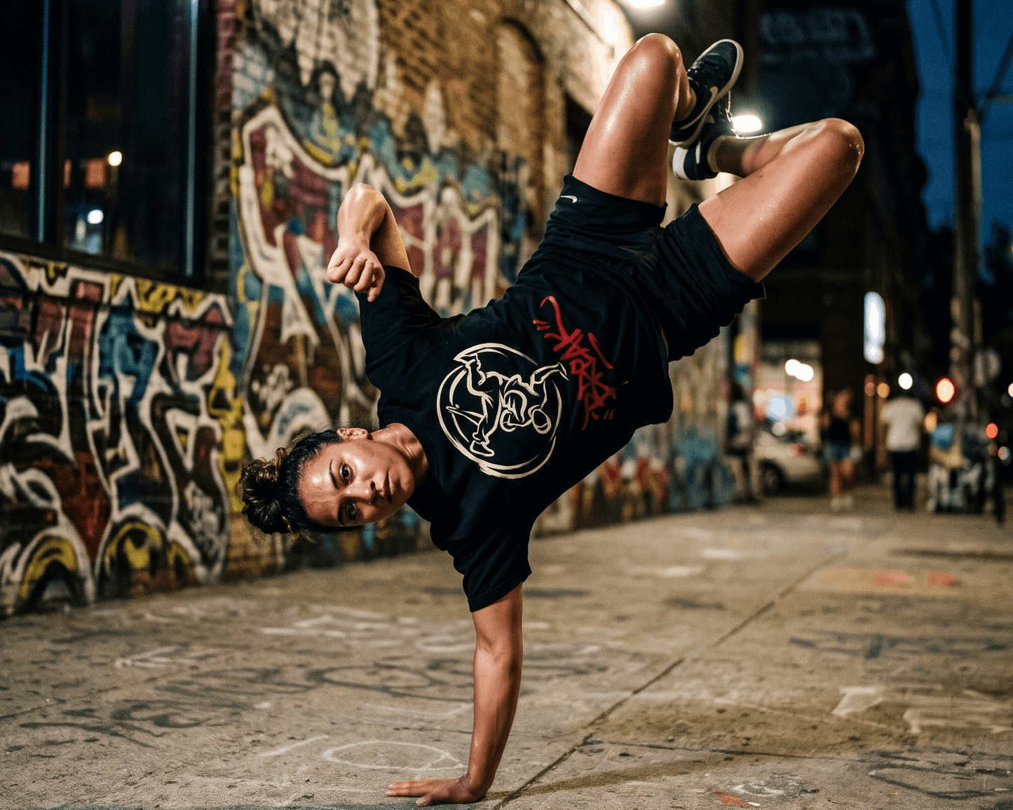 Camiseta negra con diseño de un b-boy haciendo un freeze, silueta blanca dentro de un círculo, y la palabra BREAK en rojo graffiti debajo
