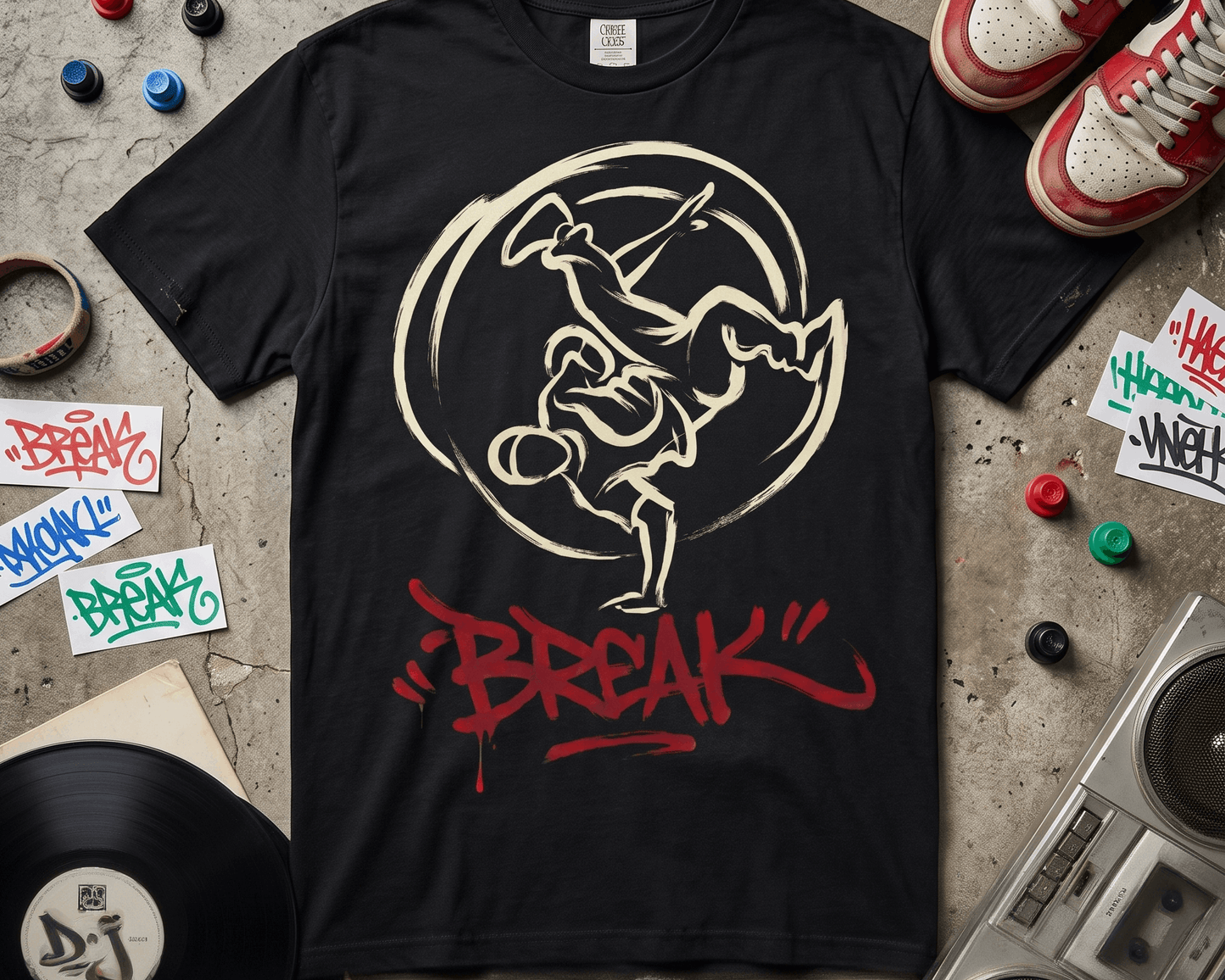 Camiseta negra con diseño de un b-boy haciendo un freeze, silueta blanca dentro de un círculo, y la palabra BREAK en rojo graffiti debajo